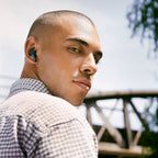 Man wearing Cambridge Audio Melomania A100 SE earbuds outdoors