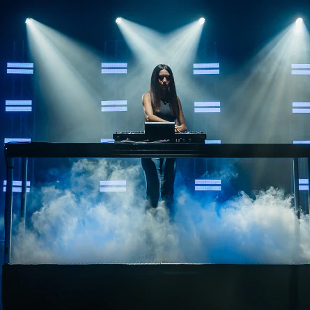 Denon DJ Prime 4 G2, DJ performing on stage with DMX lighting
