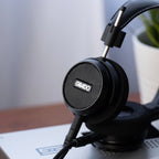Grado Signature S150 headphones resting on a desktop DAC at home