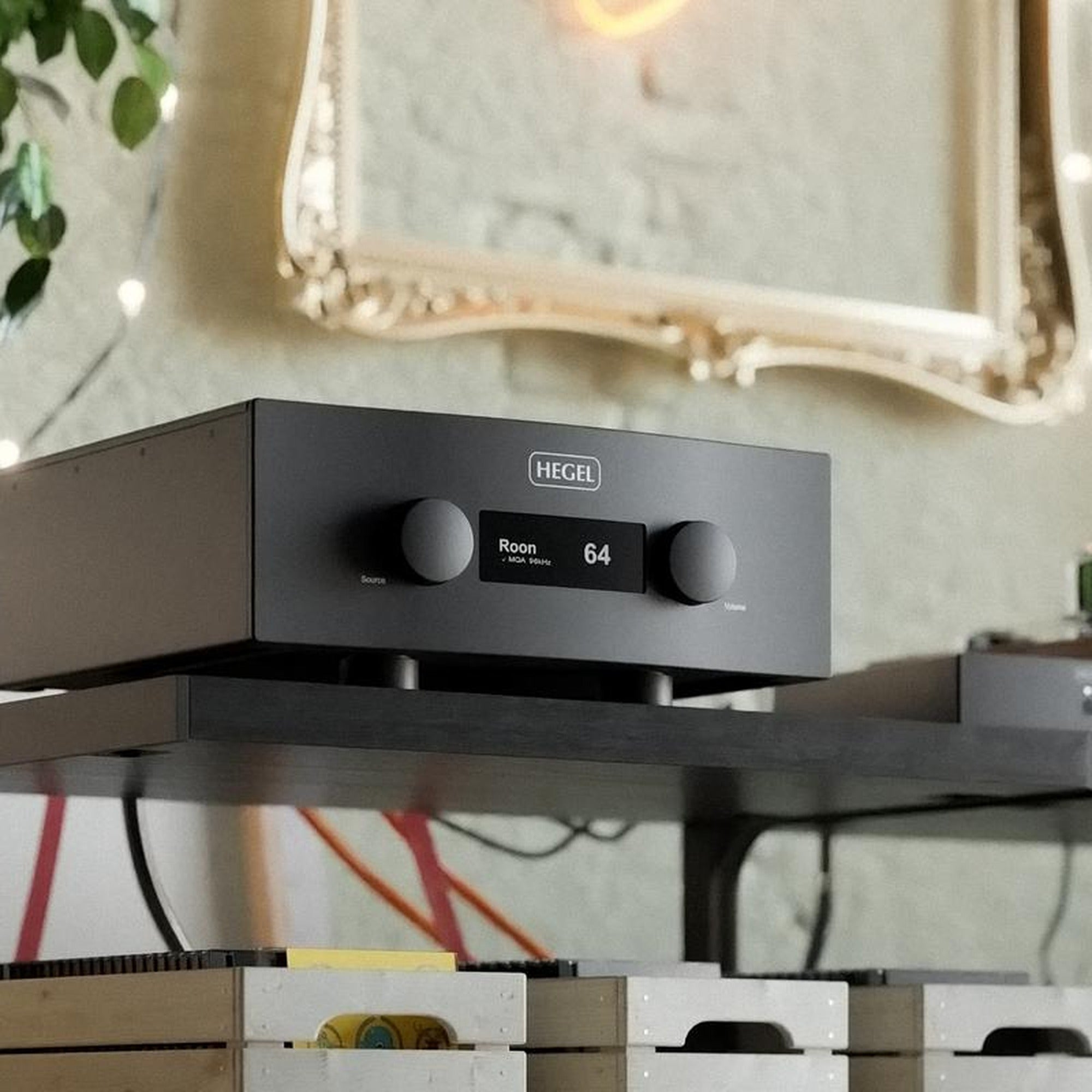 Hegel H600 integrated amplifier on a hi-fi rack above vinyl record crates in a living room