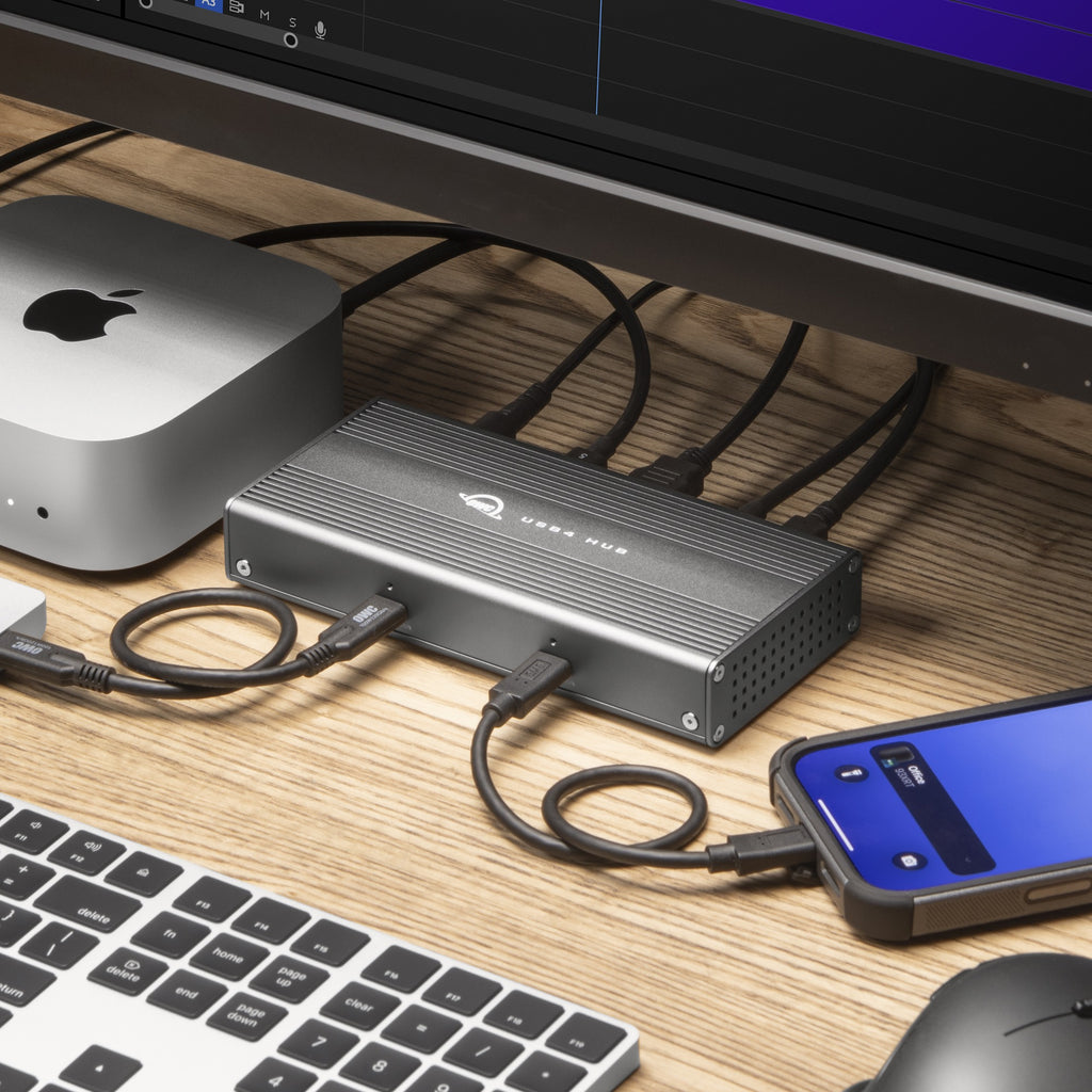 OWC USB4 Hub, close-up on desk with connected SSD and phone
